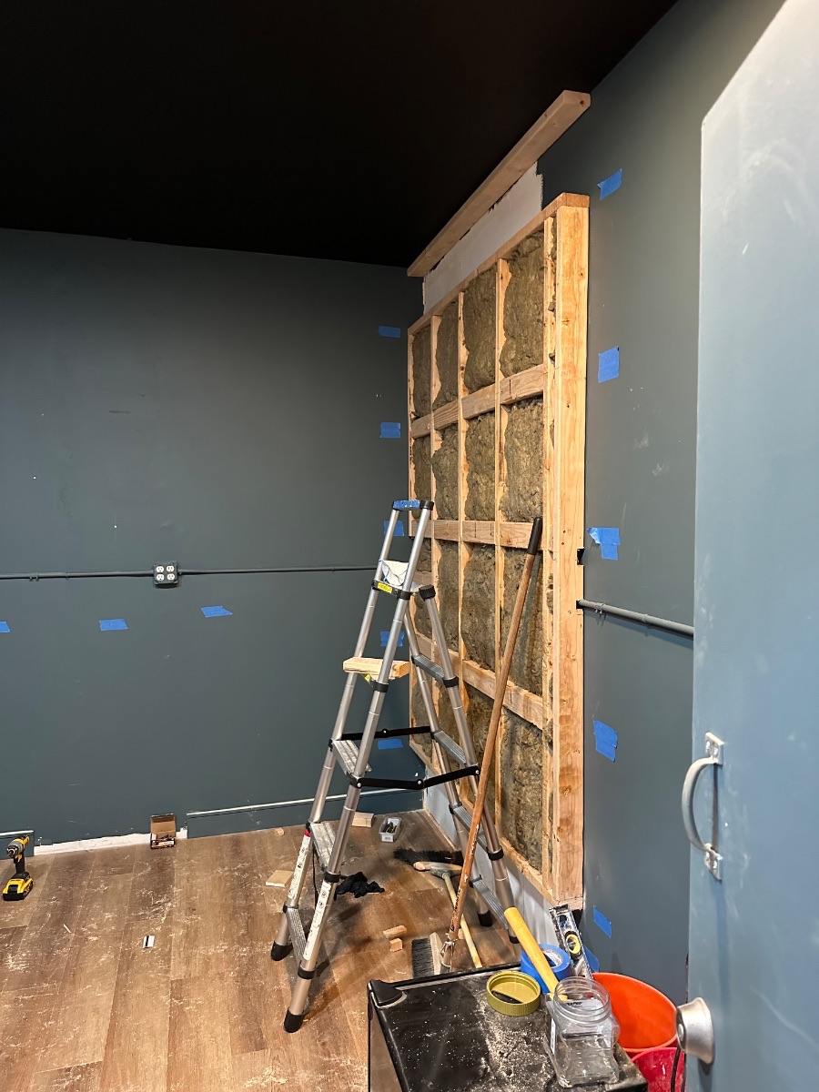 Panagraph Studios build — the framed wall insulated with mineral wool and stood in place