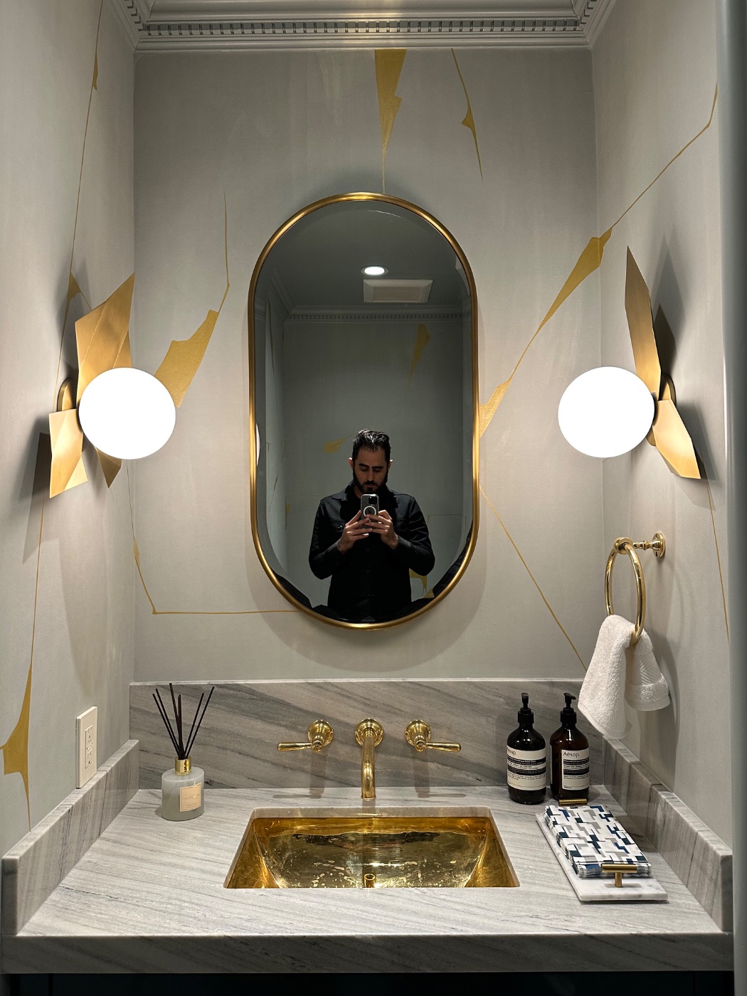 A mirror and sconces set above a marble vanity