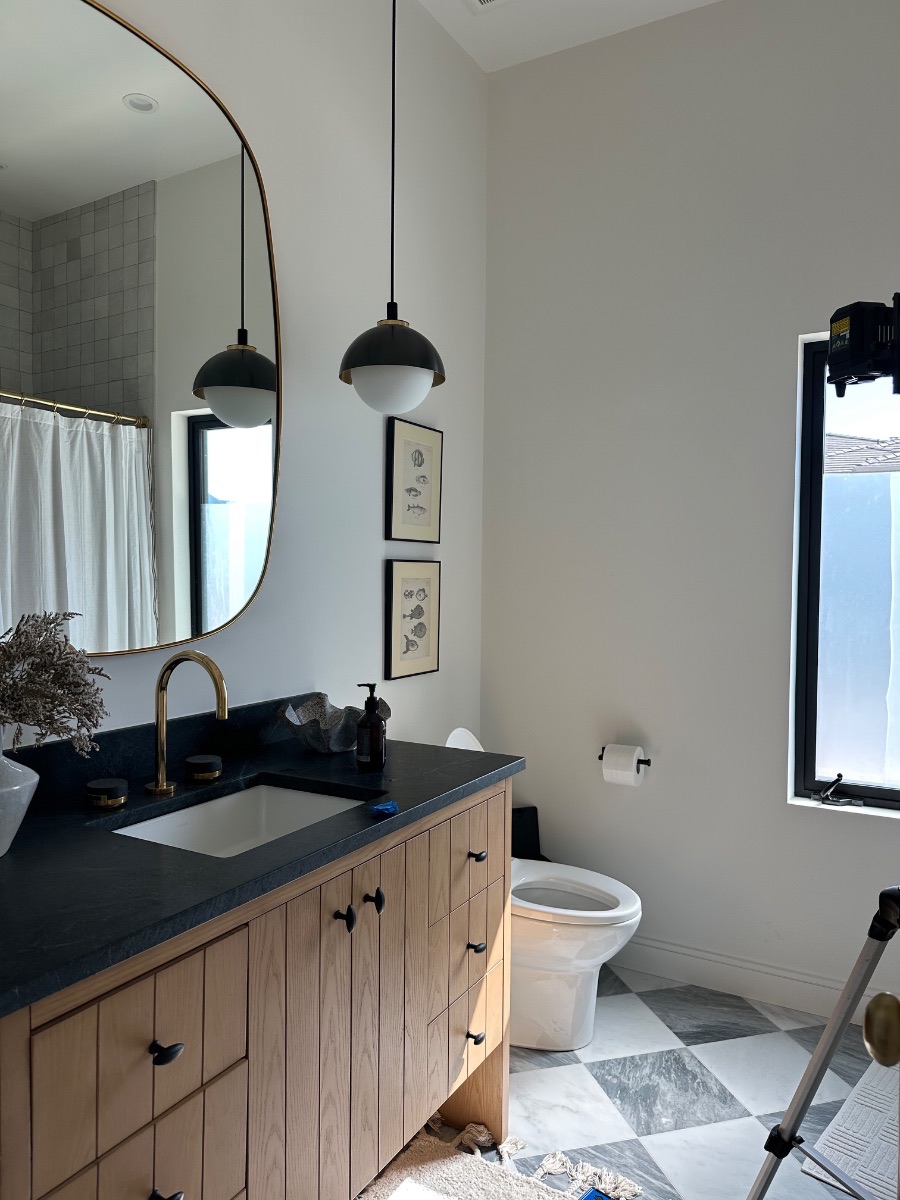 Fine art installation by Aero Luxe &mdash; Two small framed prints stacked beside the vanity, Ross, California