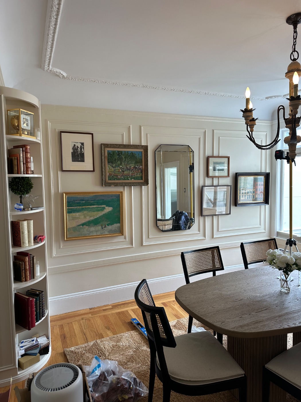 Pacific Heights — framed paintings and works on paper composed around a mirror on a panelled dining room wall, San Francisco